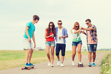 Image showing group of smiling teenagers with skateboards