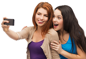 Image showing two smiling teenagers with smartphone