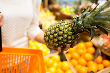 Image showing close up of woman with pineapple in grocery market