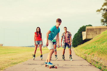 Image showing group of smiling teenagers with roller-skates