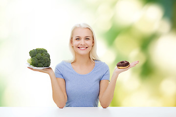 Image showing smiling woman with broccoli and donut