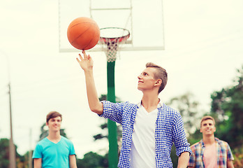 Image showing group of smiling teenagers playing basketball