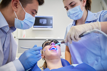 Image showing dentists treating woman patient teeth at clinic