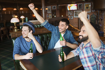 Image showing happy male friends drinking beer at bar or pub