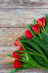 Image showing close up of red tulips on wooden background