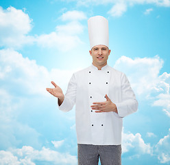 Image showing happy male chef cook inviting