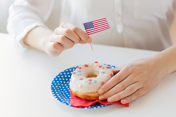 Image showing female hands decorating donut with american flag