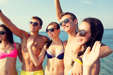 Image showing smiling friends in sunglasses on summer beach