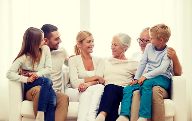 Image showing happy family sitting on couch at home