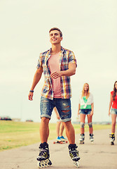 Image showing group of smiling teenagers with roller-skates