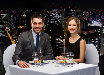 Image showing smiling couple eating main course at restaurant