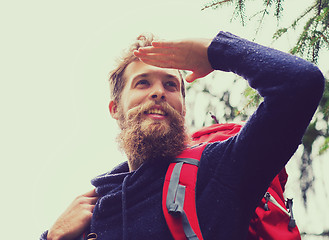 Image showing smiling man with beard and backpack hiking