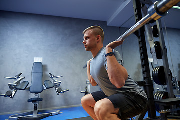 Image showing young man flexing muscles with barbell in gym