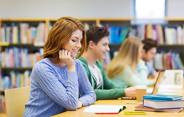 Image showing happy student girl reading books in library