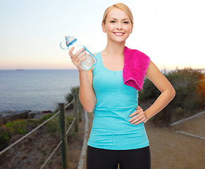 Image showing happy woman with water bottle and towel outdoors