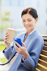 Image showing smiling woman with coffee and smartphone