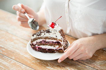 Image showing close up of woman eating chocolate cherry cake