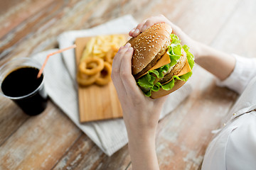 Image showing close up of woman hands holding hamburger