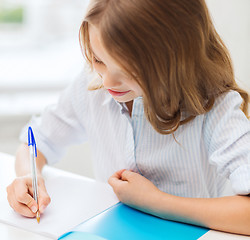 Image showing student girl writing in notebook at school