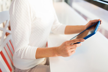 Image showing close up of woman with tablet pc at cafe