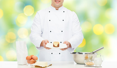 Image showing close up of happy male chef cook baking dessert