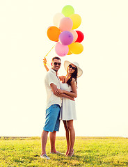 Image showing smiling couple with air balloons outdoors