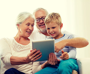 Image showing smiling family with tablet pc at home