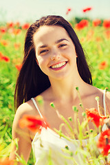 Image showing smiling young woman on poppy field