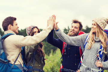 Image showing group of smiling friends with backpacks hiking