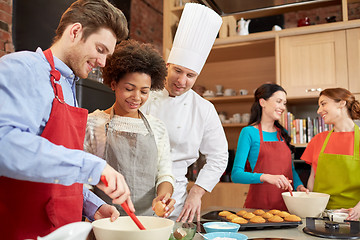 Image showing happy friends and chef cook baking in kitchen