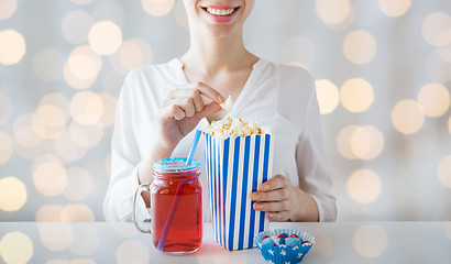 Image showing woman eating popcorn with drink in glass mason jar