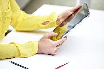 Image showing close up of female hands with tablet pc at table