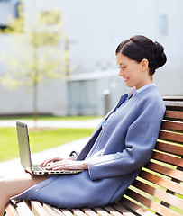 Image showing smiling business woman with laptop in city