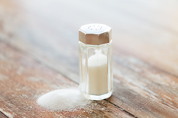 Image showing close up of white salt cellar on wooden table