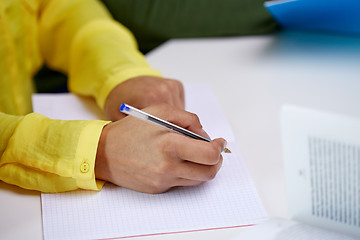 Image showing close up of female hands writing to notebook