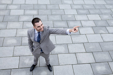 Image showing young smiling businessman outdoors from top