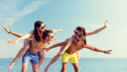 Image showing smiling friends having fun on summer beach