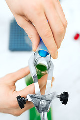 Image showing close up of scientist filling test tubes in lab