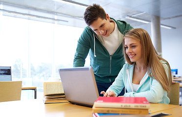 Image showing happy students with laptop in library