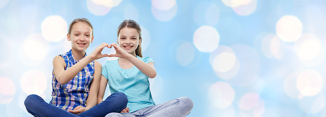 Image showing happy little girls showing heart shape hand sign