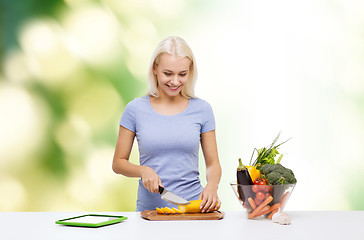 Image showing smiling young woman cooking vegetables at home