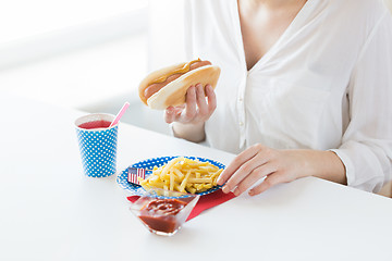 Image showing close up of woman eating hotdog and french fries