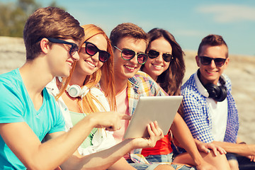 Image showing group of smiling friends with tablet pc outdoors