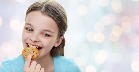 Image showing smiling little girl eating cookie or biscuit