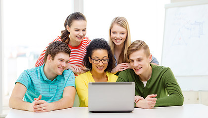 Image showing smiling students looking at laptop at school