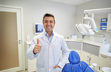 Image showing happy male dentist showing thumbs up at clinic