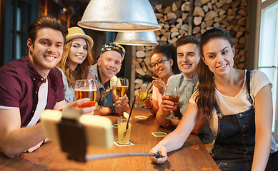 Image showing friends with smartphone on selfie stick at bar