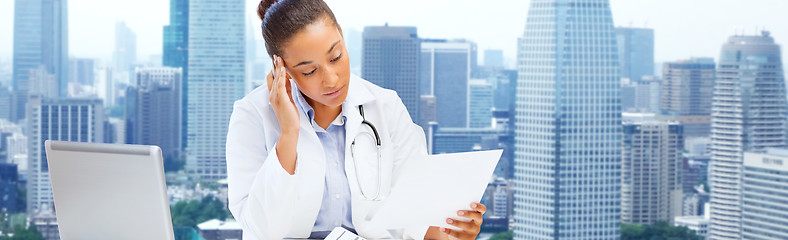 Image showing female doctor with laptop reading medical report