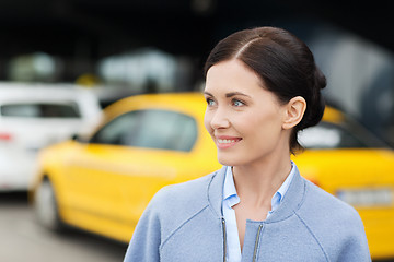 Image showing smiling woman over taxi station or city street