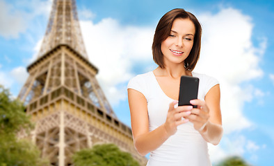 Image showing woman with smartphone over eiffel tower